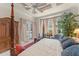 Spacious main bedroom with a sitting area, canopy bed, and access to the outdoors at 10915 Emerald Chase Dr, Orlando, FL 32836