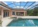 An eye-level view of the beautiful private pool and spa with a screened enclosure and patio at 10915 Emerald Chase Dr, Orlando, FL 32836