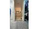 Hallway view of a bathroom featuring double sinks, white cabinets, and tiled floors; includes a glimpse into the walk-in closet at 1140 Odoniel S Loop, Lakeland, FL 33809