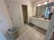 Bathroom featuring double sinks with white cabinets, tiled floors, and a separate toilet room for added privacy at 1140 Odoniel S Loop, Lakeland, FL 33809