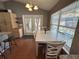 Bright dining room featuring a white table, four chairs, and a large window with blinds overlooking a pool at 1140 Odoniel S Loop, Lakeland, FL 33809