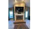 Elegant brick fireplace with a white mantel, large TV, and matching curtains on the windows at 1140 Odoniel S Loop, Lakeland, FL 33809