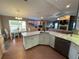 Open kitchen with granite counters, stainless appliances, white cabinetry, and views into the dining and living areas at 1140 Odoniel S Loop, Lakeland, FL 33809