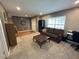 Comfortable living room with a brown sofa, office desk, and hardwood and carpet flooring at 1140 Odoniel S Loop, Lakeland, FL 33809