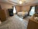 Well-lit bedroom with neutral walls, ceiling fan, grey carpet, and a sizable bed with a grey and white pattern at 1140 Odoniel S Loop, Lakeland, FL 33809
