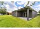 View of the backyard showing the covered patio and green lawn at 13658 Hidden Forest Cir, Orlando, FL 32828