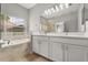 Bathroom features a large window, soaking tub, dual vanity and walk-in shower at 13658 Hidden Forest Cir, Orlando, FL 32828