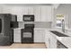 Well-lit kitchen offers white cabinets, black appliances, and ample counter space at 13658 Hidden Forest Cir, Orlando, FL 32828