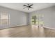 Open living room featuring a sliding glass door, ceiling fan, and hardwood style flooring at 13658 Hidden Forest Cir, Orlando, FL 32828