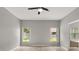 Large main bedroom with hardwood style flooring, two windows, and an attached bathroom at 13658 Hidden Forest Cir, Orlando, FL 32828