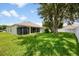 Expansive backyard featuring a screened porch, storage shed, and lush green lawn, perfect for outdoor activities at 14301 Bending Branch Ct, Orlando, FL 32824