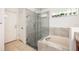 Updated bathroom with glass shower enclosure, soaking tub, and decorative window at 14301 Bending Branch Ct, Orlando, FL 32824