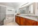 Bathroom with granite countertops, wooden cabinets, a large framed mirror, and a soaking tub at 14301 Bending Branch Ct, Orlando, FL 32824