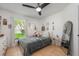 Bright bedroom with neutral walls, ceiling fan, and decorative mirror at 14301 Bending Branch Ct, Orlando, FL 32824