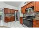 Kitchen featuring stainless steel appliances, granite countertops, tile backsplash, and cherry colored wood cabinets at 14301 Bending Branch Ct, Orlando, FL 32824