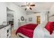 Comfortable main bedroom featuring a red bedspread, a ceiling fan, and neutral wall color at 14301 Bending Branch Ct, Orlando, FL 32824