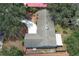 Aerial view of a well-maintained home with a light roof, surrounded by mature trees, a swimming pool, and a curved driveway at 1481 Glastonberry Rd, Maitland, FL 32751