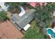An aerial shot of a house featuring a light-colored roof, surrounded by mature trees and a swimming pool with a diving board at 1481 Glastonberry Rd, Maitland, FL 32751