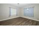 Inviting bedroom with wood-look flooring and natural light from two windows at 1481 Glastonberry Rd, Maitland, FL 32751