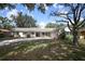Inviting home with mature trees, a well-manicured lawn, and a quaint covered entryway at 1481 Glastonberry Rd, Maitland, FL 32751