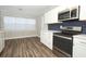 Updated kitchen boasts stainless steel appliances, white cabinets, quartz countertops, and navy blue subway tile backsplash at 1481 Glastonberry Rd, Maitland, FL 32751