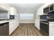 Updated kitchen features stainless steel appliances, white cabinets, quartz countertops, and navy blue subway tile backsplash at 1481 Glastonberry Rd, Maitland, FL 32751