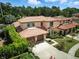 Aerial view of a beautiful home with lush greenery, manicured lawns, and a red tile roof at 1769 Turnberry Ter, Orlando, FL 32804