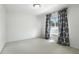 Bright bedroom with neutral carpet, white walls, and window with patterned curtains at 1769 Turnberry Ter, Orlando, FL 32804