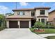 Elegant two-story home with a terracotta roof, lush landscaping, and a two-car garage in a suburban neighborhood at 1769 Turnberry Ter, Orlando, FL 32804