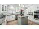 Bright, modern kitchen with white cabinets, stainless steel appliances, an island, and herringbone backsplash at 1769 Turnberry Ter, Orlando, FL 32804