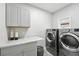 Clean laundry room with a countertop, cabinets, and modern washer and dryer at 1769 Turnberry Ter, Orlando, FL 32804