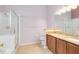 Bright bathroom with double sinks, granite countertops, and a glass-enclosed shower at 204 Grovepark Dr, Davenport, FL 33837