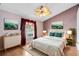 Comfortable bedroom with hardwood floors, a ceiling fan, and a large window at 204 Grovepark Dr, Davenport, FL 33837