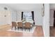 Inviting dining room with hardwood floors, large window, seating for six, and French doors at 204 Grovepark Dr, Davenport, FL 33837