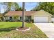 Charming one-story home with manicured lawn, palm tree and a two-car garage at 204 Grovepark Dr, Davenport, FL 33837