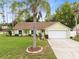 Charming one-story home with manicured lawn, palm tree and a two-car garage at 204 Grovepark Dr, Davenport, FL 33837