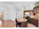 Open kitchen featuring wood cabinets, granite counters, and a breakfast bar overlooking the living room at 204 Grovepark Dr, Davenport, FL 33837