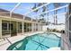 Enclosed screened in pool with access from the house and lush landscaping at 204 Grovepark Dr, Davenport, FL 33837