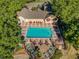 An aerial view of a sparkling blue swimming pool nestled between trees and a clubhouse at 2065 Dixie Belle Dr # O, Orlando, FL 32812