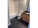 Bathroom featuring a combination tub and shower, toilet, sink and vanity with a dark tile floor at 2065 Dixie Belle Dr # O, Orlando, FL 32812