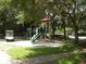 Community playground with slides, a golf cart, and mature trees providing shade at 2065 Dixie Belle Dr # O, Orlando, FL 32812