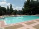 A community pool surrounded by tables and greenery providing a refreshing outdoor space at 2065 Dixie Belle Dr # O, Orlando, FL 32812
