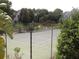 View of tennis court with lush landscaping and community buildings in the background at 2065 Dixie Belle Dr # O, Orlando, FL 32812
