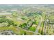 A stunning aerial view of a Primary-planned community with lush green golf courses, lakes, and tree-lined streets at 2173 Caledonian St, Clermont, FL 34711