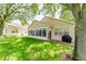 Lovely backyard with green grass, mature trees and an enclosed patio and outdoor grill at 2173 Caledonian St, Clermont, FL 34711