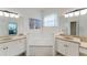 Bright bathroom featuring a deep soaking tub and dual vanities with granite countertops at 2173 Caledonian St, Clermont, FL 34711