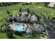 Aerial view of the clubhouse with a large pool, palm trees, manicured lawns and ample parking at 2173 Caledonian St, Clermont, FL 34711