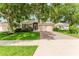 Inviting single-story home with a brick driveway, two-car garage, and lush green lawn framed by mature trees at 2173 Caledonian St, Clermont, FL 34711