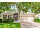 Charming single-story home featuring a brick driveway, attached two-car garage, and well-maintained landscaping at 2173 Caledonian St, Clermont, FL 34711