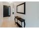 Bright hallway with tiled floor, black console table and decorative mirror, and a front door with glass window at 2173 Caledonian St, Clermont, FL 34711